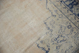 Distressed vintage Oushak carpet with visible wear, abrashed ivory field, and cobalt blue pattern.