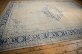 Distressed cobalt blue geometric border and ivory field of the vintage Oushak rug, showing knot wear.