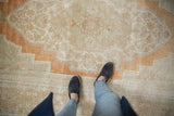 Distressed vintage Oushak carpet, abrashed pile in blended rust, sand, and beige.