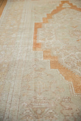 Distressed Oushak carpet showing stepped orange motif and subtle ivory background patterns.