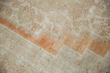 Distressed Oushak pile with abrash and soft burnt orange, sand, and ivory tones.