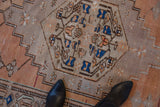 Distressed Oushak runner: pinwheel vinery, worn terracotta, sand, blue texture.