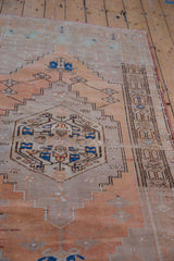 Decorative coffee brown geometric border detail on a distressed terracotta Oushak runner.