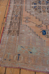 Worn terracotta field and brown geometric border of a distressed Oushak runner.
