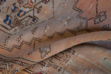 Vintage Oushak runner's distressed low pile, showing terracotta, sand, and brown floral vinery.