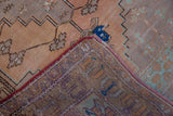 Distressed Oushak runner corner showcasing low pile, sturdy hand-knotted foundation, and red selvage.