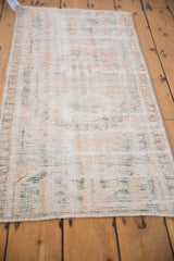 Distressed Oushak rug runner with worn texture and soft, faded pastel tones.
