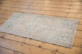 Intact pale rose side selvage and worn pile of the distressed Oushak runner.
