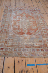 Worn terracotta, ivory, and pale blue border patterns on a Distressed Oushak rug corner.
