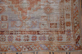 Distressed Oushak rug corner with rust, ivory, pale blue barber pole border and fringe.