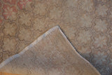 Vintage Distressed Oushak rug corner, revealing worn beige pile, hand-knotted foundation, and intact selvage.