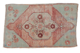 Vintage distressed Oushak rug with faded raspberry floral medallion and abrashed sea foam green field.