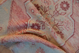 Distressed Oushak rug pile texture showing mostly even wear with raspberry and beige.