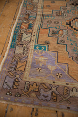 Distressed Oushak rug detail: geometric patterns, muted turquoise, lavender, and terracotta hues.
