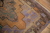 Distressed Turkish Oushak rug detail with geometric floral buds, featuring sandalwood, lavender, and dusty terracotta.