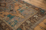 Distressed Turkish Oushak rug corner with worn pile, geometric motifs, and intact side cord.