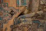 Textured pile and geometric patterns with dusty turquoise on a distressed Oushak rug.