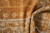 Soft folds reveal distressed texture, copper, gold, beige hues of the vintage Oushak rug.