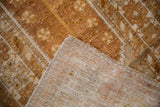 Corner of distressed Oushak rug, showing copper pile texture and hand-knotted reverse foundation.