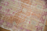 Distressed pile of the vintage Oushak rug, revealing worn knot heads and faded fuchsia.