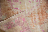 Distressed Oushak rug's worn pile texture and vivid fuchsia from the reverse side.