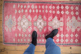 Abrashed pale cochineal red Oushak rug with ivory and oxidized silver floral diamond pattern.