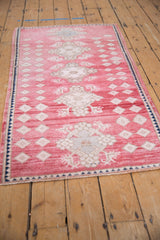 Textured blush cochineal field with ivory geometric and floral Oushak motifs.
