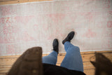 Distressed Oushak rug runner with faded blush stepped outlines and low, soft texture.