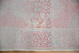 Distressed vintage Oushak rug pile with blush and ivory geometric patterns showing faint foundation.