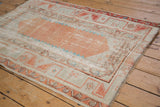 Artfully distressed pale terracotta abrashed field with turquoise accents and vine border.