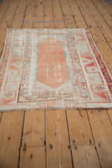 Distressed vintage Oushak rug end showing short fringe, visible foundation, terracotta, and ivory borders.
