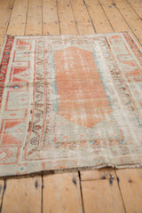 Textural view of distressed pale terracotta Oushak rug with intricate meandering vine borders.
