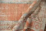 Distressed Oushak rug texture with visible foundation, muted terracotta, ivory, and turquoise.