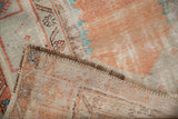 Detail of distressed vintage Oushak rug showing worn pile, exposed foundation, and woven reverse.