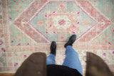 Distressed vintage Oushak carpet, stepped medallion with faded seafoam and raspberry tones underfoot.