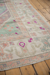 Distressed texture of vintage Oushak carpet with seafoam green, pale aubergine, and ivory starburst motifs.