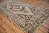 Distressed Oushak runner featuring a central geometric medallion and floral finial motif.