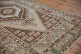 Distressed Oushak runner detail with chocolate brown border, lightning stepped contour, and floral motifs.