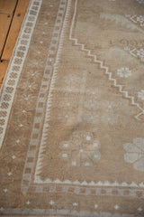 Distressed pale coffee brown Oushak runner pile texture with ivory geometric designs.