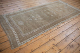 Distressed vintage Oushak runner corner, showing even wear, pale coffee brown, and ivory patterns.