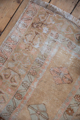 Distressed vintage Oushak rug with muted pink and pale blue germinating plant motifs.