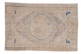 Distressed vintage Turkish Oushak rug, ivory and blush tones, cobalt blue roundel medallion and seed motifs.