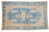 Distressed Oushak carpet, denim blue medallion with ornate florals, beige field.