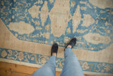 Distressed Oushak rug with soft denim blue and ivory tones, displaying faded floral patterns.