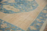 Distressed Turkish Oushak carpet's sky blue field, beige floral motifs, and short pile.
