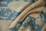 Distressed texture and curled edge of a denim blue and ivory Oushak rug.