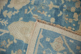 Distressed blue and ivory Oushak carpet showing short pile, original selvage, and fringe.