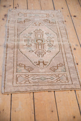 Angled vintage distressed Oushak rug with ivory, brown, and soft blue geometric medallion.