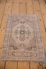 Distressed Oushak rug with worn pile, ivory, bronze, and faded blue-green geometric motif.
