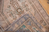 Vintage Oushak rug corner showing distressed ivory pile and tight hand knotted foundation.